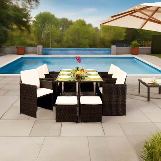 Rattan garden furniture located on patio next to large swimming pool